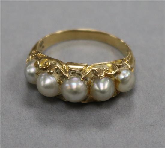 A yellow metal and graduated five stone split pearl half hoop ring, size J.